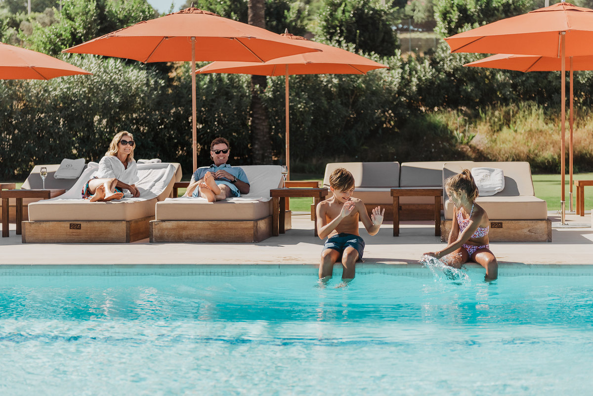 Familia junto a la piscina de La Reserva Club
